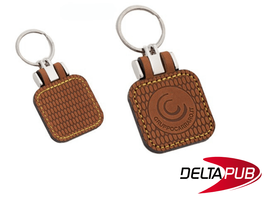 Deux porte-clés en simili cuir marron texturé avec surpiqûres et marquage en creux personnalisé.